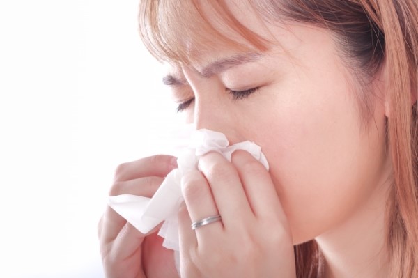 アレルギーで鼻をかむ女性
