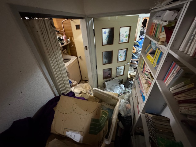 千葉県船橋市 ゴミがあふれかえって扉が十分に開けられない廊下